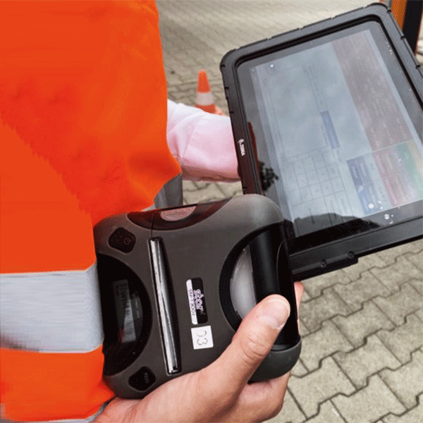 Hände eines Menschen, der ein Tablet in der linken Hand und einen mobilen Drucker in der rechten Hand hält